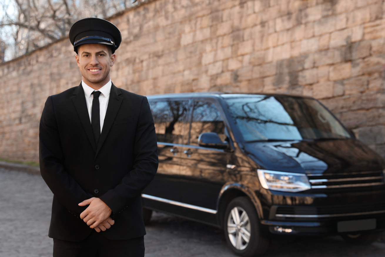 Professional Driver near Luxury Car on Street. Chauffeur Service